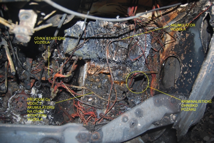 Na obr. je ukázka z fotodokumentace, která se zpracovává k požáru a je součástí spisu o požáru. Na tomto snímku je zachycena část motorového prostoru osobního automobilu v místě ohniska požáru.
