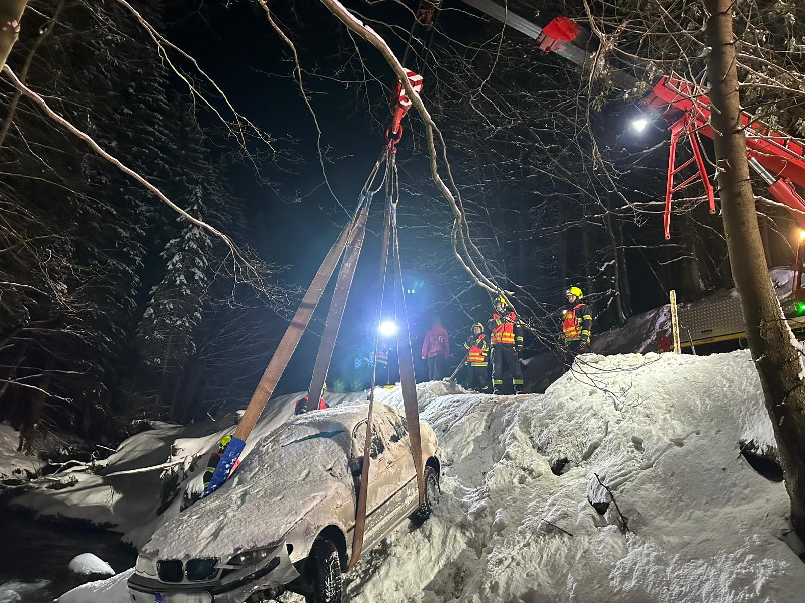 Automobil, který o den dříve havaroval a skončil v říčce Jizerce, už byl zasněžený. Zasahující hasiči vozidlo zajistili speciálními textilními popruhy a pomocí ramene jeřábu se jim podařilo jej vyprostit