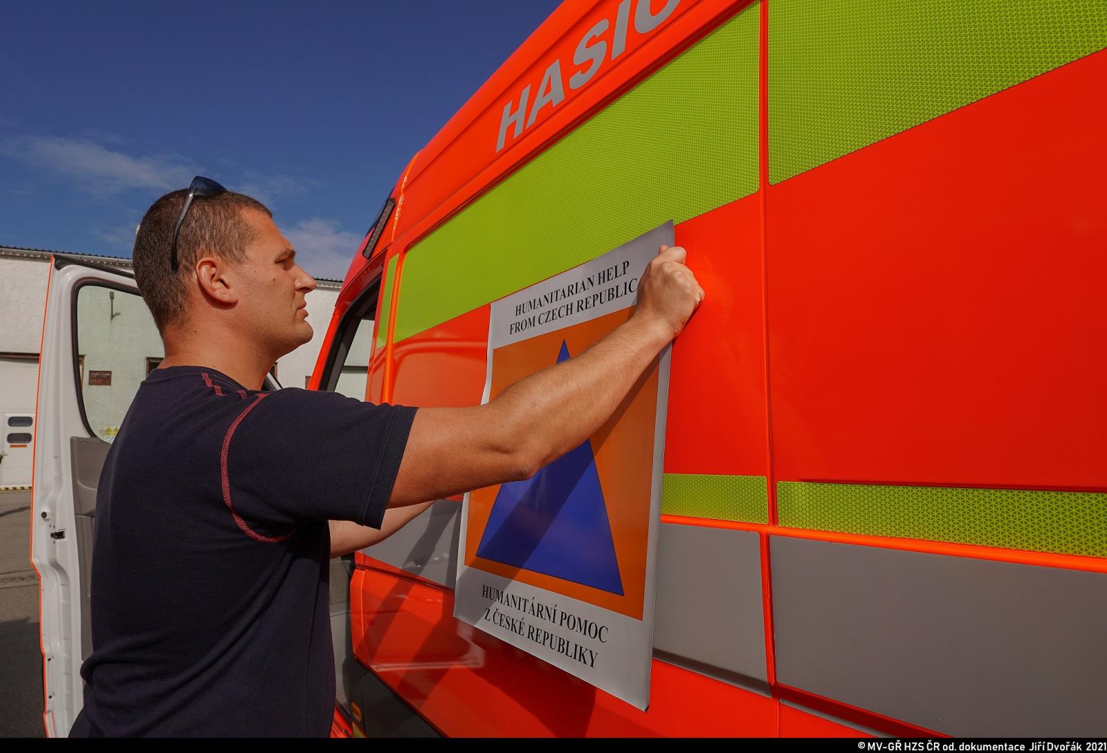 Čeští hasiči vyrazili na pomoc Řecku zasaženému ničivými požáry_jeden z hasičů označuje vůz.jpg