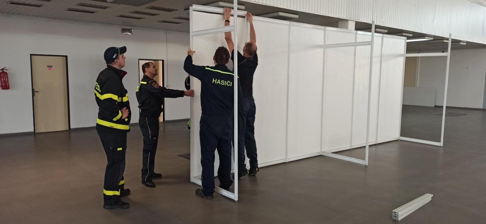 Stavba KACPU na brněnském výstavišti_1.3._hasiči staví přepážky.jpg
