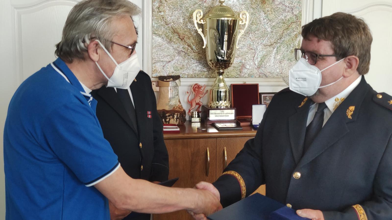 Vladislav Čermák přebírá pamětní plaketu od ředitele HZS Plzeňského kraje.jpg