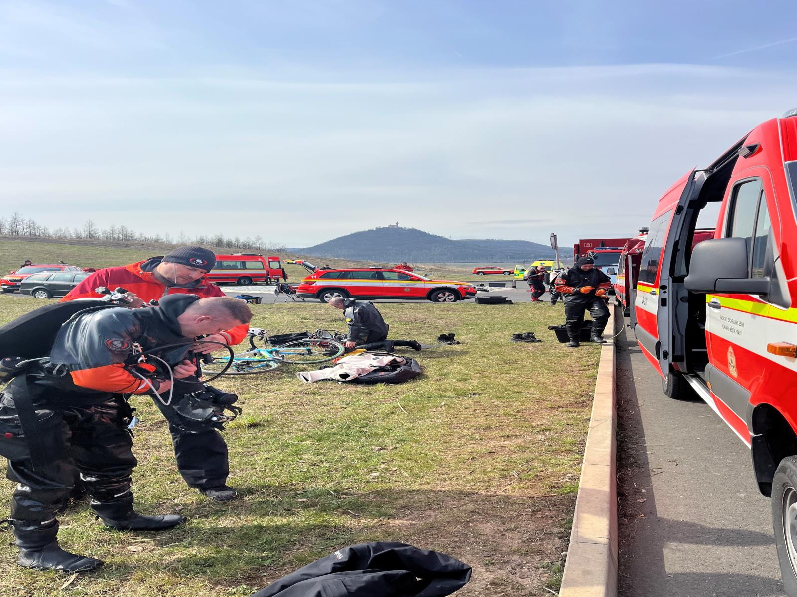 Výcvik na jezeře Most_hasičtí potapěči se u aut oblékají do obleků.jpg