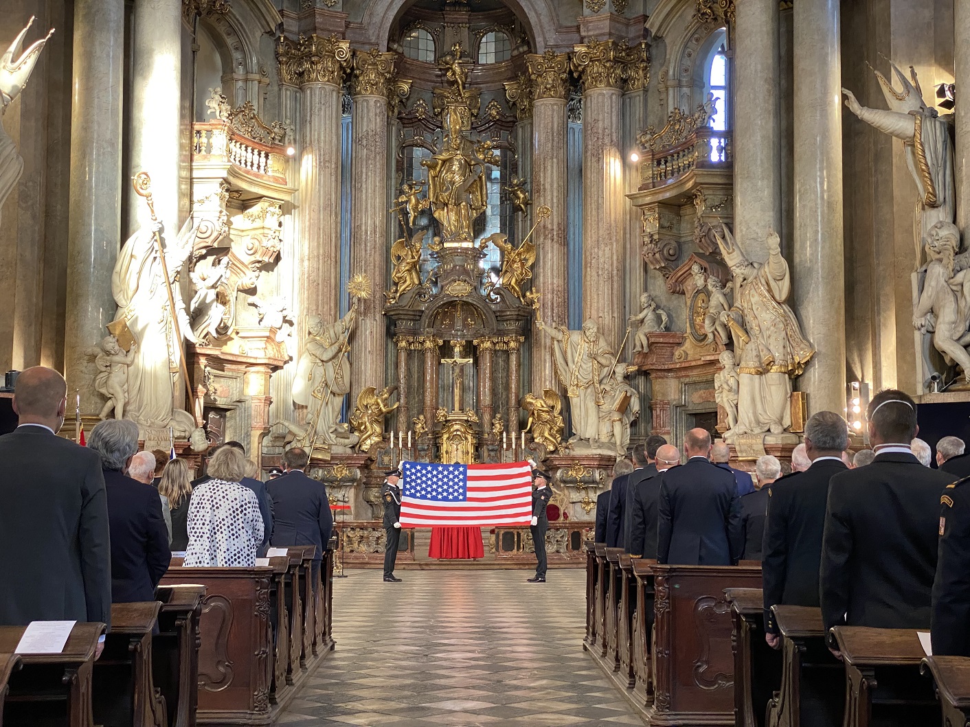 13_Hosté pietní akce ve stoje sledují Čestnou stráž Hasičského útvaru ochrany Pražského hradu skládající americkou vlajku.jpg