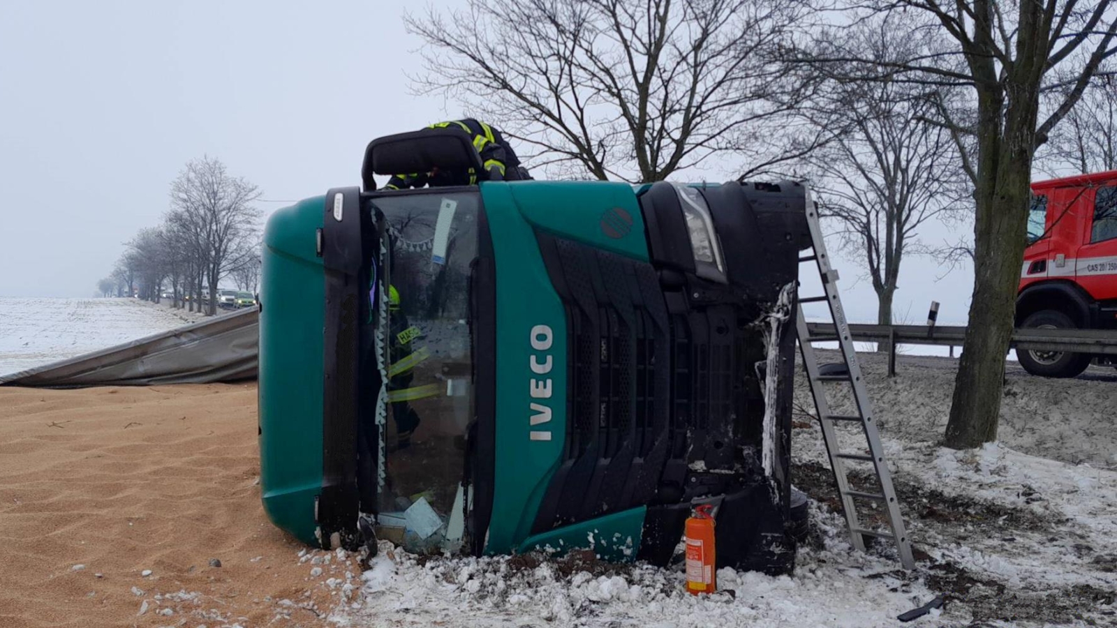 130126-Vyprošťování řidiče z převráceného kamionu s obilím na silnici č. 38 u obce Krchleby na Nymbursku.jpg
