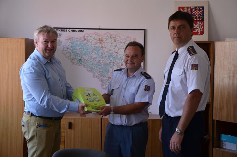 Starosta města Hlinska Miroslav Krčil předává veliteli stanice npor. Hynku Weberovi nový defibrilátor. Vpravo ředitel HZS Pardubického kraje, územního oddboru Chrudim plk. Leoš Vávra.