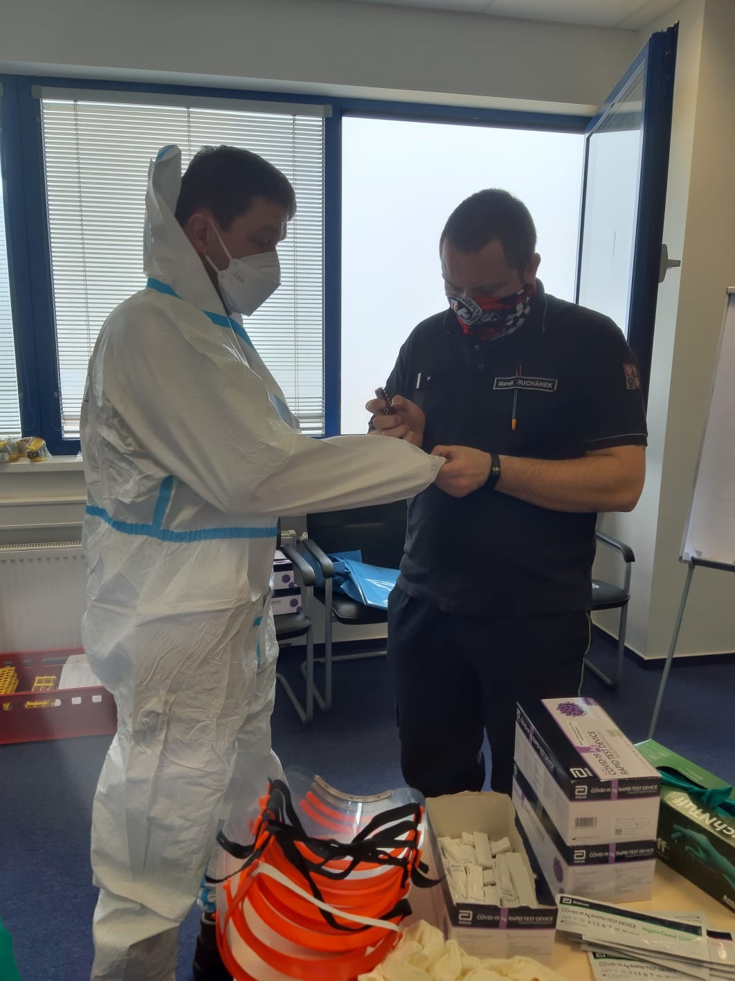 006 - spolupráce při oblékání do ochranných obleků.jpg