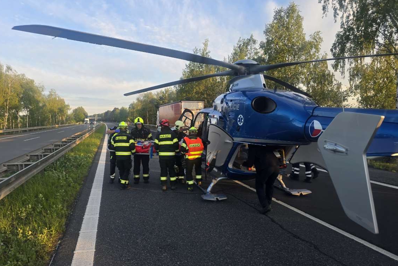 160626-Transport pacienta do vrtulníku po nehodě na dálnici D6 u Stochova na Kladensku.jpg