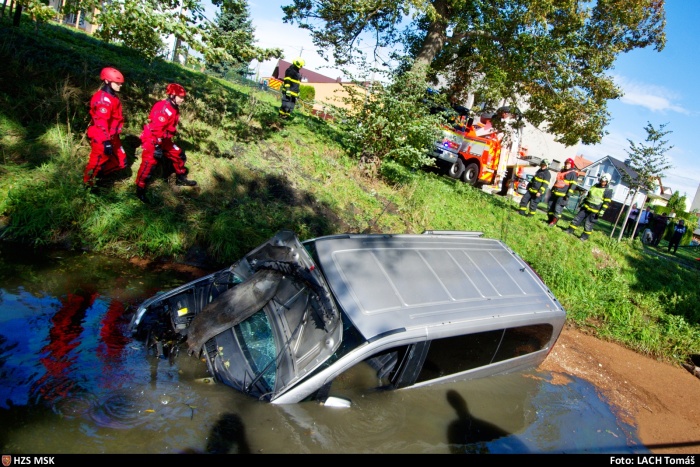 MSK_dodávka potopená v náhonu a hasiči, kteří se připravují k zásahu.jpg