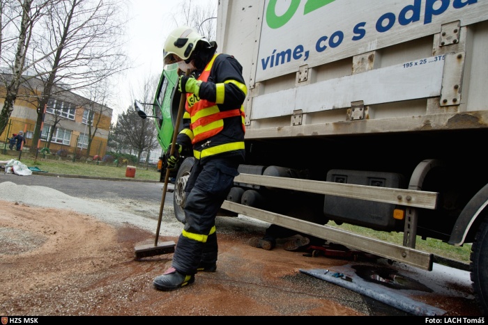 MSK_odstranění olejové skvrny z vozovky_hasič rozhrnuje sorbent na vozovku.jpg
