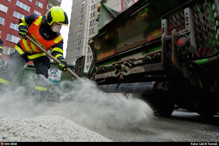 MSK_odstranění olejové skvrny z vozovky_hasič sypající sorbent na vozovku.jpg