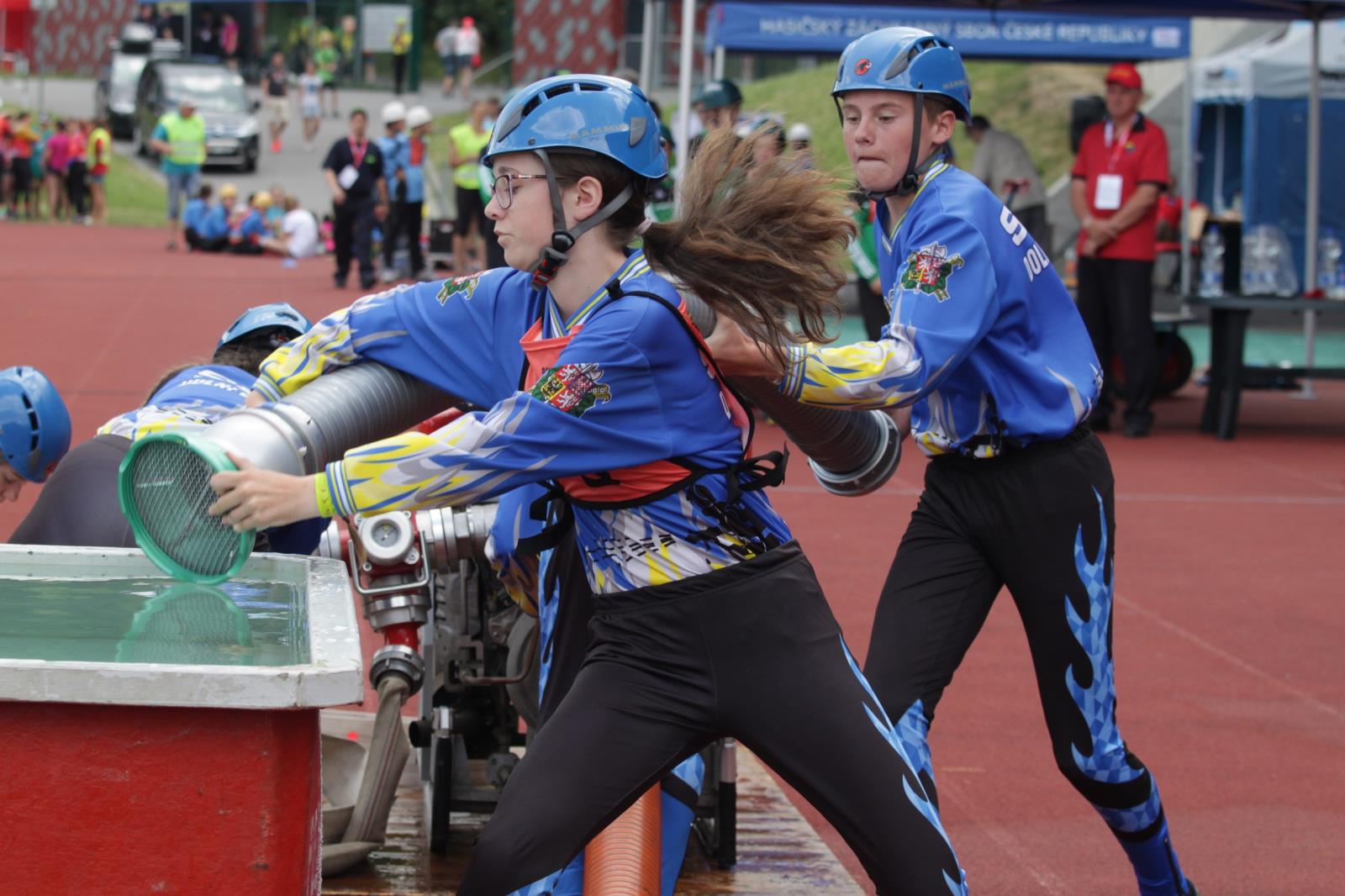 Mistrovství ČR hry Plamen_nedělní závod_závodníci vnořují hadici do kádě.JPG