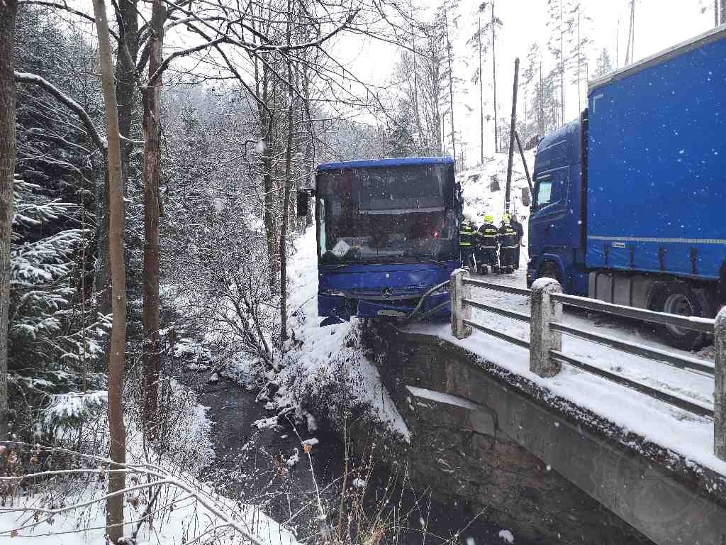 PAK_DN autobusu_hasiči pomáhají cestujícím dostat se ven z autobusu visícího nad potokem.jpg