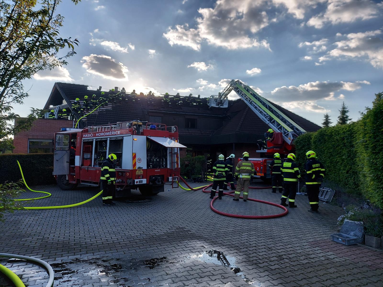 SČK_Požár RD v Horoměřicích_pohled na velké množství hasičů na střeše domu.jpg