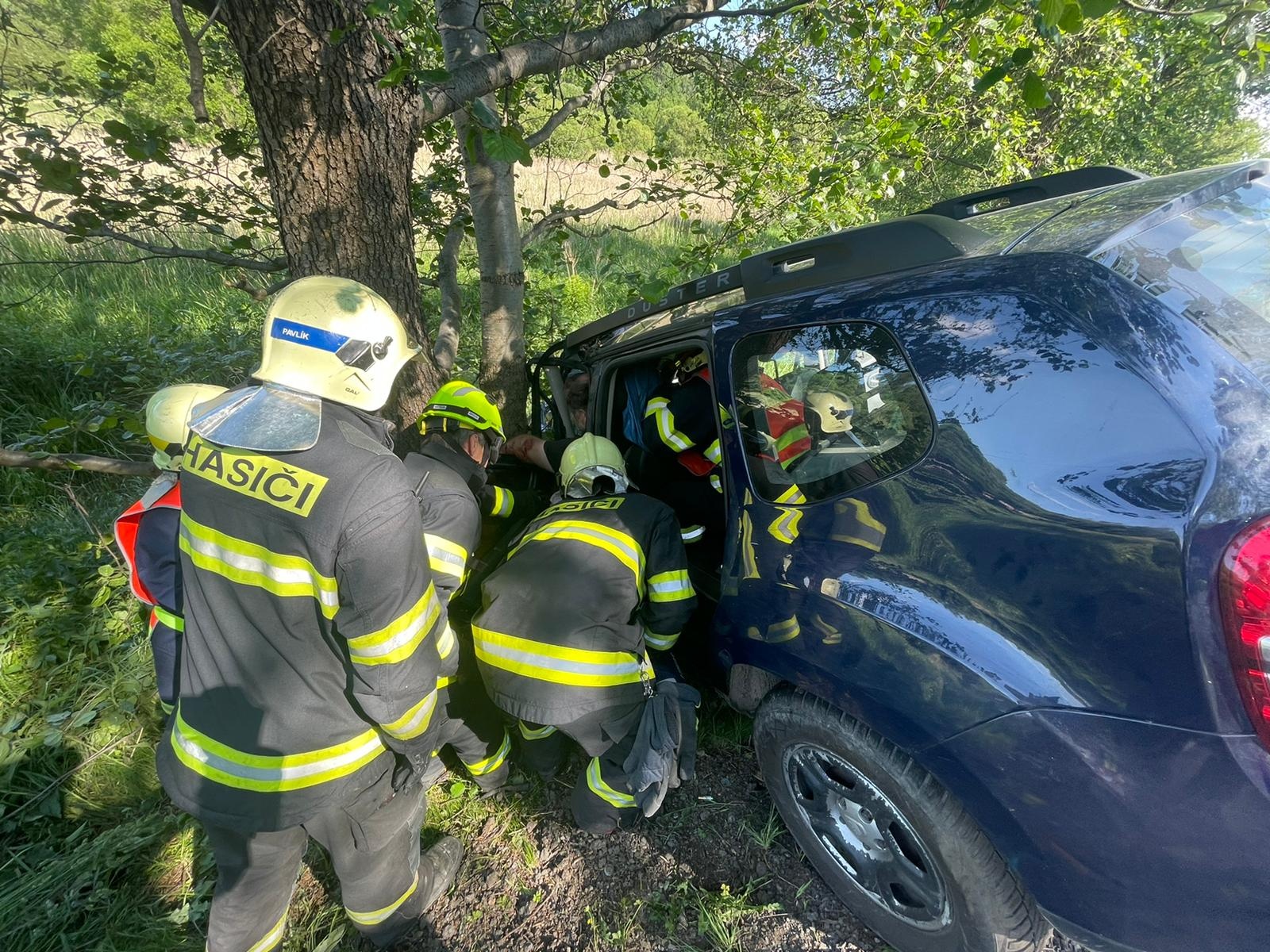 SČK_Vážná dopravní nehoda u Mirošovic_hasiči vyprošťují zraněnou osobu.jpg