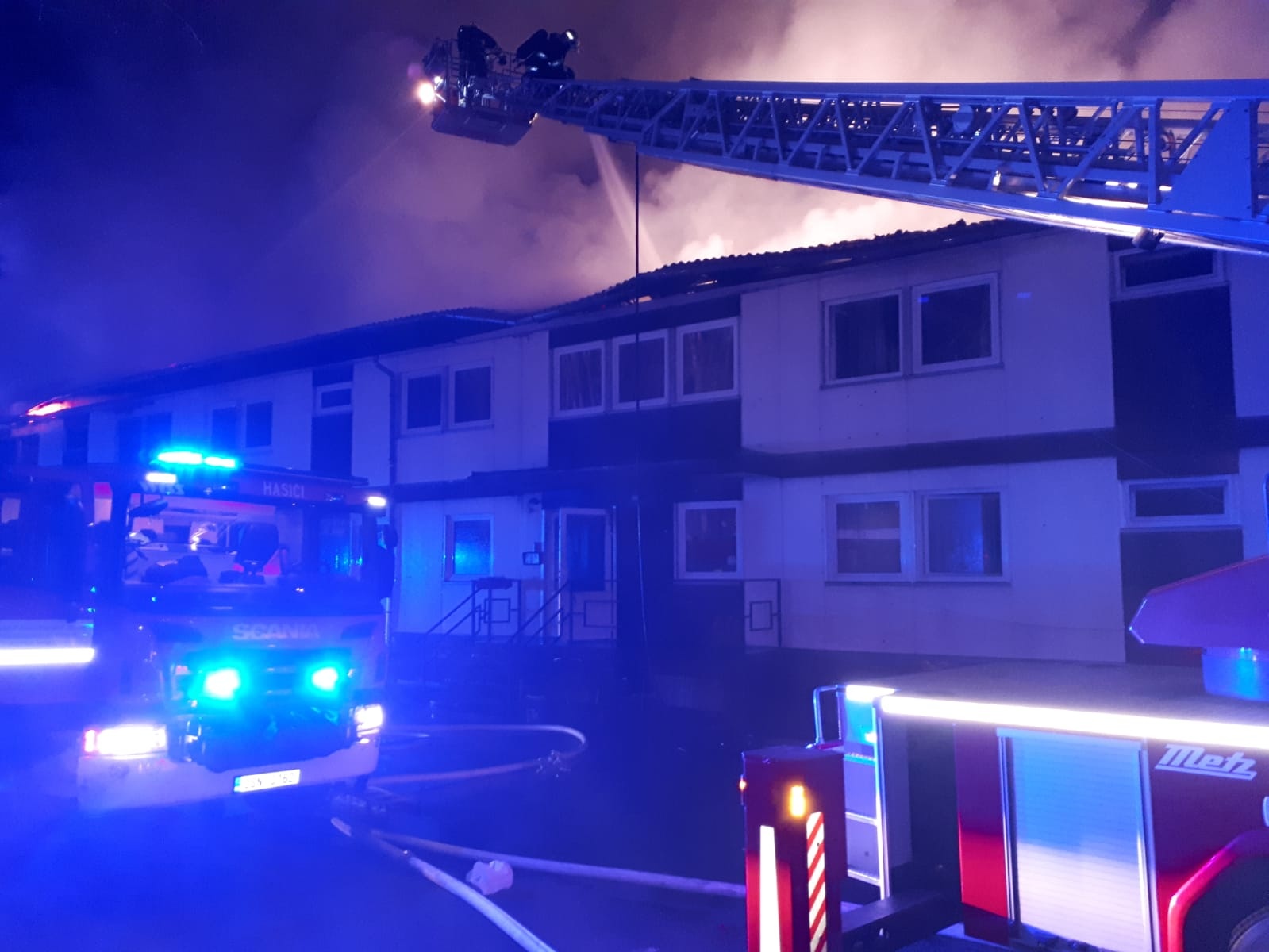 SČK_požár ubytovny v obci Sedlec_hašení střechy objektu z plošiny žebříku.jpg