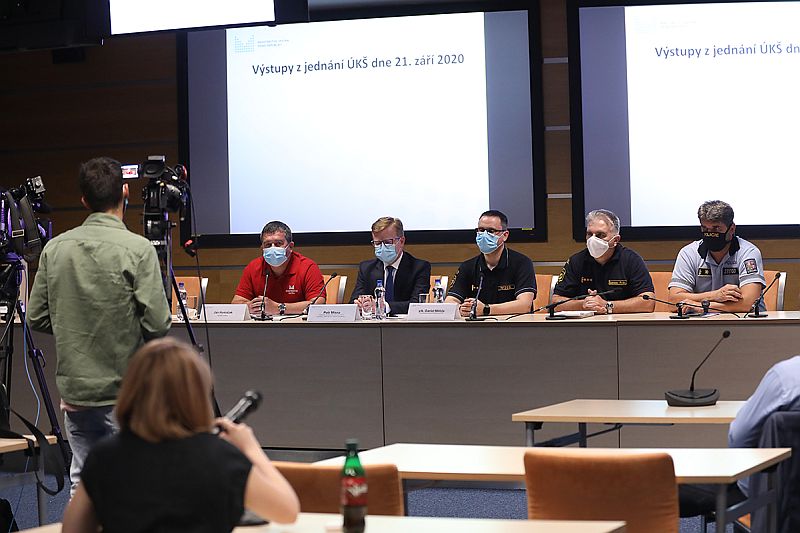 Tisková konference - pohled na předsednický stůl se členy ÚKŠ a novináři v popředí