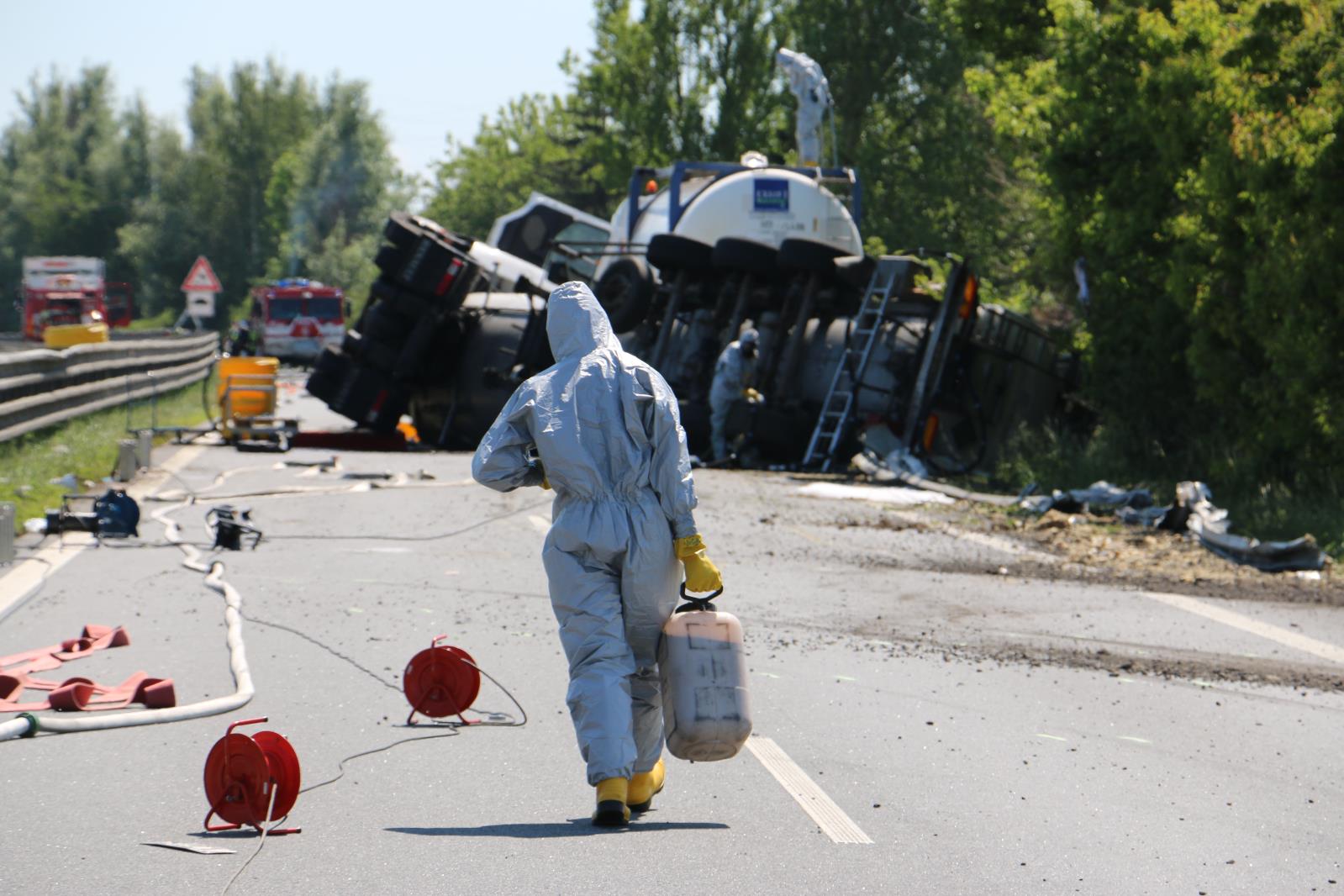 11_OLK_DN cisternového vozidla s nebezpečnou látkou_hasič v ochranném obleku jde s barelem v ruce ke kolegům u cisterny.jpg