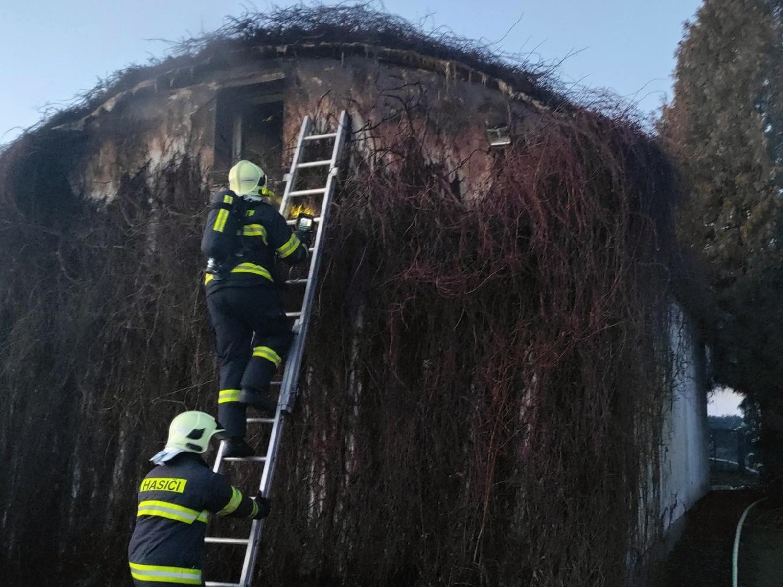 300125-Neobvyklý požár garáže po vzplanutí porostu od rozpálené lampy na vnější zdi objektu ve Velimi na Kolínsku.jpg