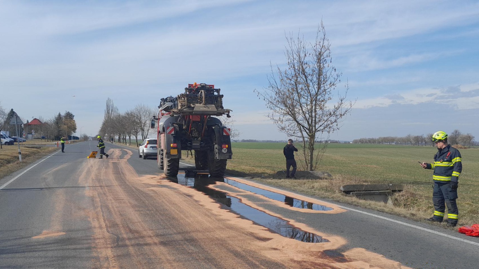120325-Lividace úniku hydraulického oleje z postřikovače na silnici za Jenčí ve směru do Uhnoště v okrese Praha-západ.jpg
