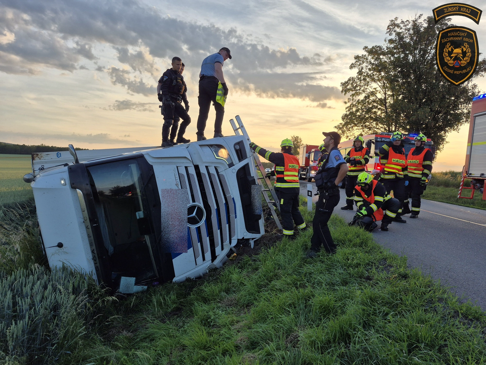 Kamion skončil po nehodě převrácený v poli